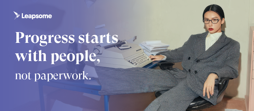 Leapsome banner with the tagline “Progress starts with people, not paperwork.” A person in a gray checkered suit sits confidently at a desk with an old-fashioned typewriter and stacked papers.